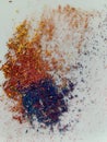 Graphite shavings of violet blue yellow and red colors spread on a white background