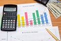 Graphs, charts, business table with money, calculator and pen Royalty Free Stock Photo