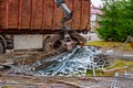 A grapple truck loads scrap industrial metal for recycling.