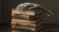 Grasping Ancient Knowledge: Skeletal Hand on Old Books Royalty Free Stock Photo