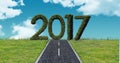 2017 in grass against a composite image 3D of asphalt road in the sky