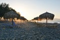 Grass beach umbrellas sunset in Greece Royalty Free Stock Photo