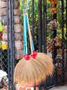 Grass broom hanging on wire fence in garden, select focus