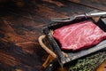 Grass Fed raw flank beef meat steak in wooden tray with herbs. Wooden background. Top view. Copy space Royalty Free Stock Photo