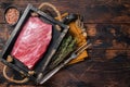 Grass Fed raw flank beef meat steak in wooden tray with herbs. Wooden background. Top view. Copy space Royalty Free Stock Photo