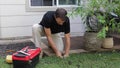 Plumber Man fixing Sprinkler Head in backyard