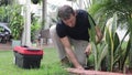 Plumber Man fixing Sprinkler Head in backyard