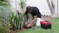 Plumber Man fixing Sprinkler Head in backyard