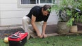 Plumber Man fixing Sprinkler Head in backyard