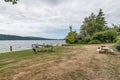 Grass filled with fire pit and chairs picnic table and dock on lake Ocean mountains Bellingham Pacific Northwest luxury