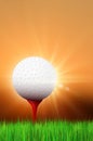 Grass, golf ball on red tee and shiny sunset Royalty Free Stock Photo