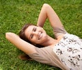 The grass is greener on the side that lets you lie down. Portrait of a beautiful young woman relaxing in the outdoors. Royalty Free Stock Photo