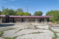 Grass grows through the cracks in the parking lot at an abandoned motel Royalty Free Stock Photo