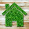 Grass home icon on wooden Royalty Free Stock Photo