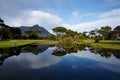 Grass, lake and trees on golf course with mountain, clouds and natural landscape with river in park. Nature, green and Royalty Free Stock Photo