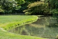 Grass lawn grows to edge of pond Royalty Free Stock Photo