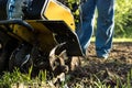 Grass and plowed soil nuggets during motor cultivator spring farm outdoor work