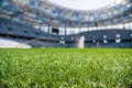 Grass on stadium in sunlight. Closeup of a green football field. Wet stadium grass in the morning light during watering Royalty Free Stock Photo