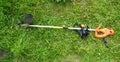 Grass trimmer in the garden. Lawnmower on the grass. Royalty Free Stock Photo