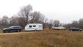 On the grassy bank of the river there are cars with a caravan trailer for a comfortable fishing vacation and with a lafette with a Royalty Free Stock Photo