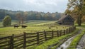 Grassy field with cows, house, and splitrail fence under cloudy sky