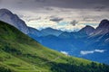 Grassy slopes with dirt road and chalet in Carnic Alps Italy