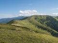 Grassy green hills and slopes at ridge of Low Tatras mountains with hiking trail footpath, mountain meadow, and pine Royalty Free Stock Photo