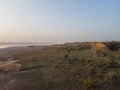 Grassy hill rises to a clear blue sky with serene lake below Royalty Free Stock Photo