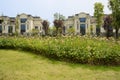 Grassy lawn and flowers on slope before fenced villas in sunny s