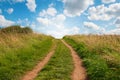 Grassy path facing uphill with blue sky. Royalty Free Stock Photo