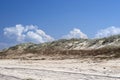 Grassy Sand-dunes with Puffy Clouds in a Bright Blue Sky