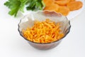 Grated carrots in a bowl, peeled and cut into pieces carrots, parsley