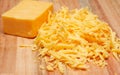 Grated cheddar cheese on wooden board Royalty Free Stock Photo