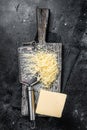 Grated cheese for cooking on a cutting board . Black background. Top view Royalty Free Stock Photo