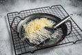 Grated cheese for cooking in a steel tray with grater. White background. Top view Royalty Free Stock Photo