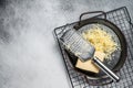 Grated cheese for cooking in a steel tray with grater. White background. Top view. copy space Royalty Free Stock Photo