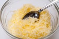 Grated cheese in a crystal bowl with spoon Royalty Free Stock Photo