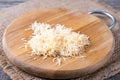 Grated cheese on a cutting board on a wooden table