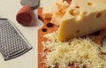 Grated cheese, Maasdam, on a cutting board, grater and cheese knife, close-up, no people,