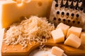 Grated cheese, Maasdam, on a cutting board, grater and cheese knife, close-up, no people,