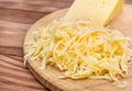 Grated cheese and piece of cheese on cutting board