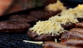 Grated cheese piled on top of a barbecued beefburger Royalty Free Stock Photo