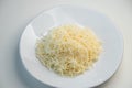 Grated cheese on a white plate close-up. Grated cheese salad, restaurant serving of the dish Royalty Free Stock Photo
