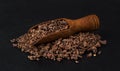 Grated chocolate in wooden scoop isolated on black background, closeup Royalty Free Stock Photo