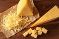 Grated and cut delicious cheese on wooden background Royalty Free Stock Photo