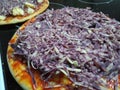 Grated fresh portwine Derby cheese on an uncooked pizza