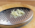 Grated garlic. Metal kitchen tool. Preparing an ingredient