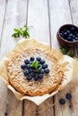 Grated rustic pie with ricotta, berries and almond flakes on natural wooden background