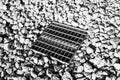 Grated storm drain inlet surrounded by rock for soil erosion control Royalty Free Stock Photo