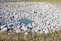 Grated storm drain inlet surrounded by rock for soil erosion control Royalty Free Stock Photo